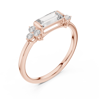 Emerald Cut Diamond Three-Stone Engagement Ring featuring an emerald-cut center stone with round diamond side accents on a polished band by Aortas Jewels.