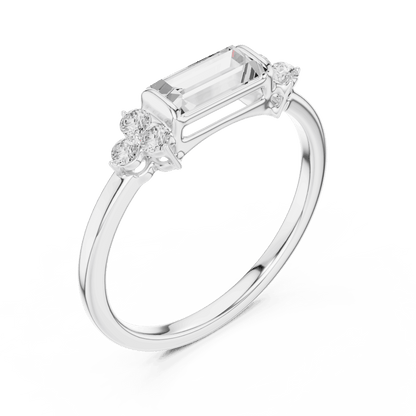 Emerald Cut Diamond Three-Stone Engagement Ring featuring an emerald-cut center stone with round diamond side accents on a polished band by Aortas Jewels.